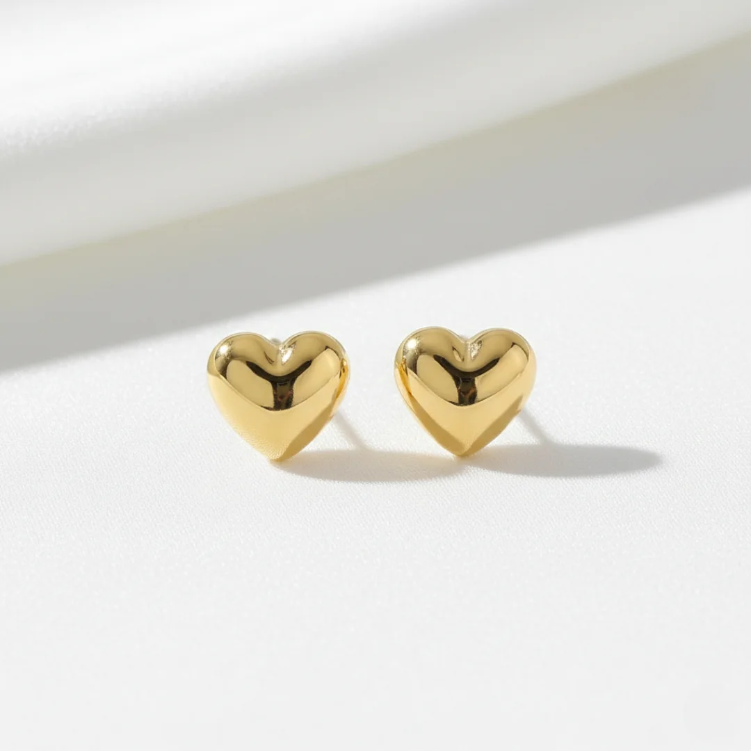 Gold heart-shaped earrings on a white background