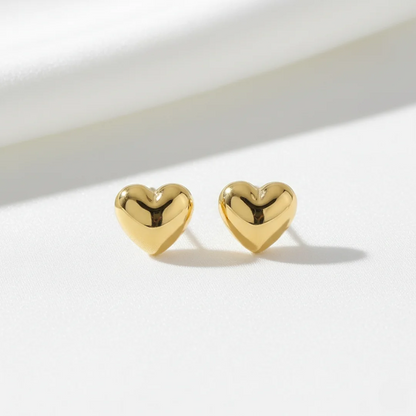 Gold heart-shaped earrings on a white background