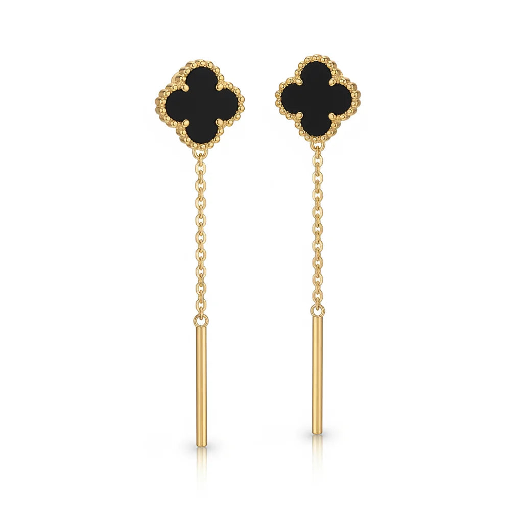 Pair of gold earrings with black clover-shaped tops on a white background