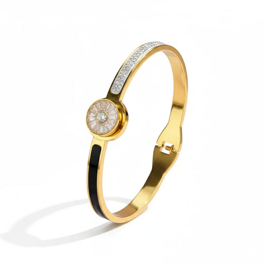 Gold bracelet with a central circular design on a white background