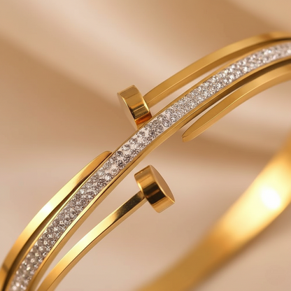 Gold bracelet with diamond accents on a beige background