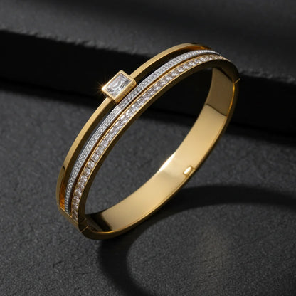 Gold bracelet with diamond accents on a dark background
