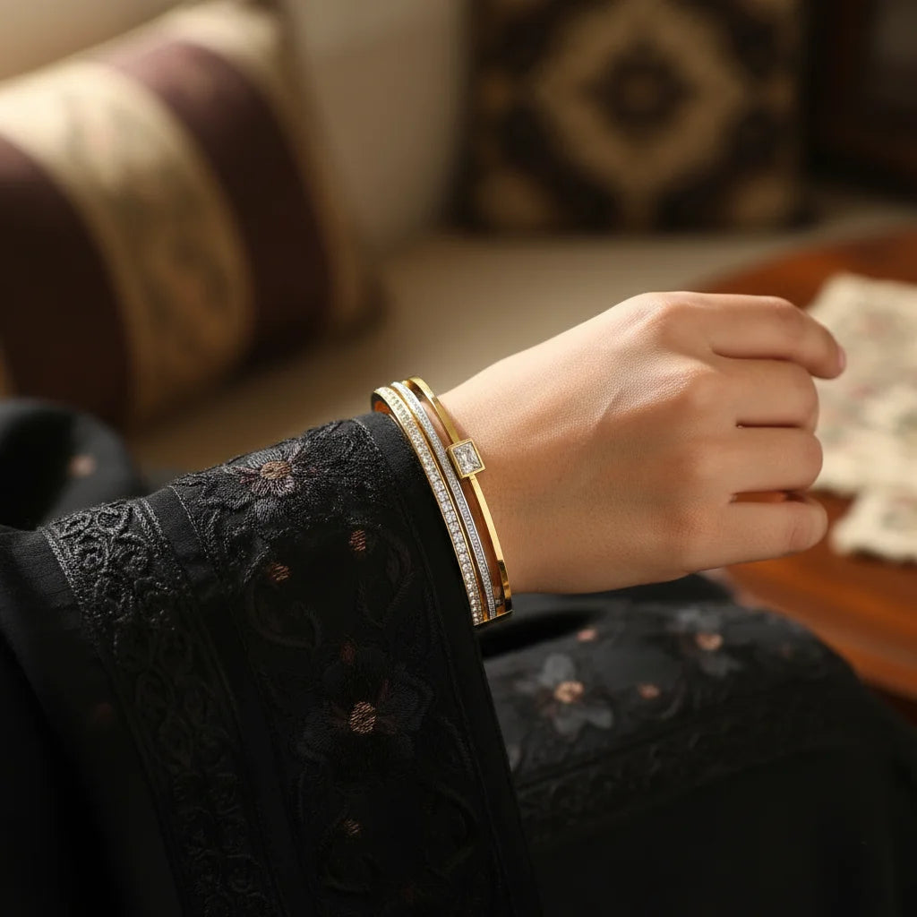 Hand wearing a gold bracelet with a blurred background