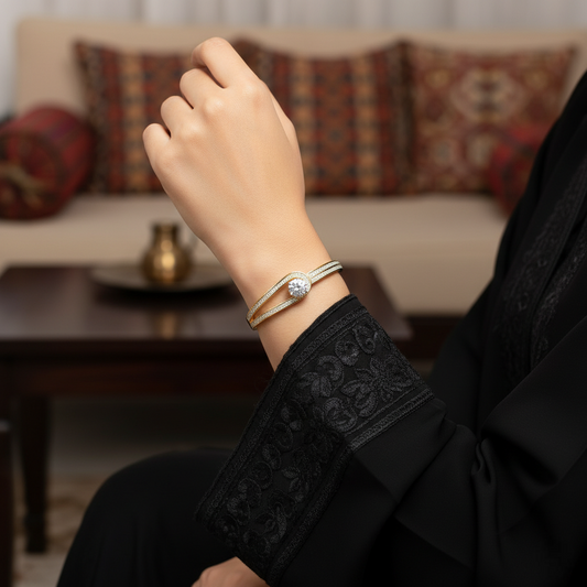 Hand wearing a bracelet with a blurred background of a living room.