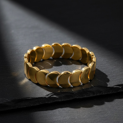 Gold bracelet on a dark stone surface