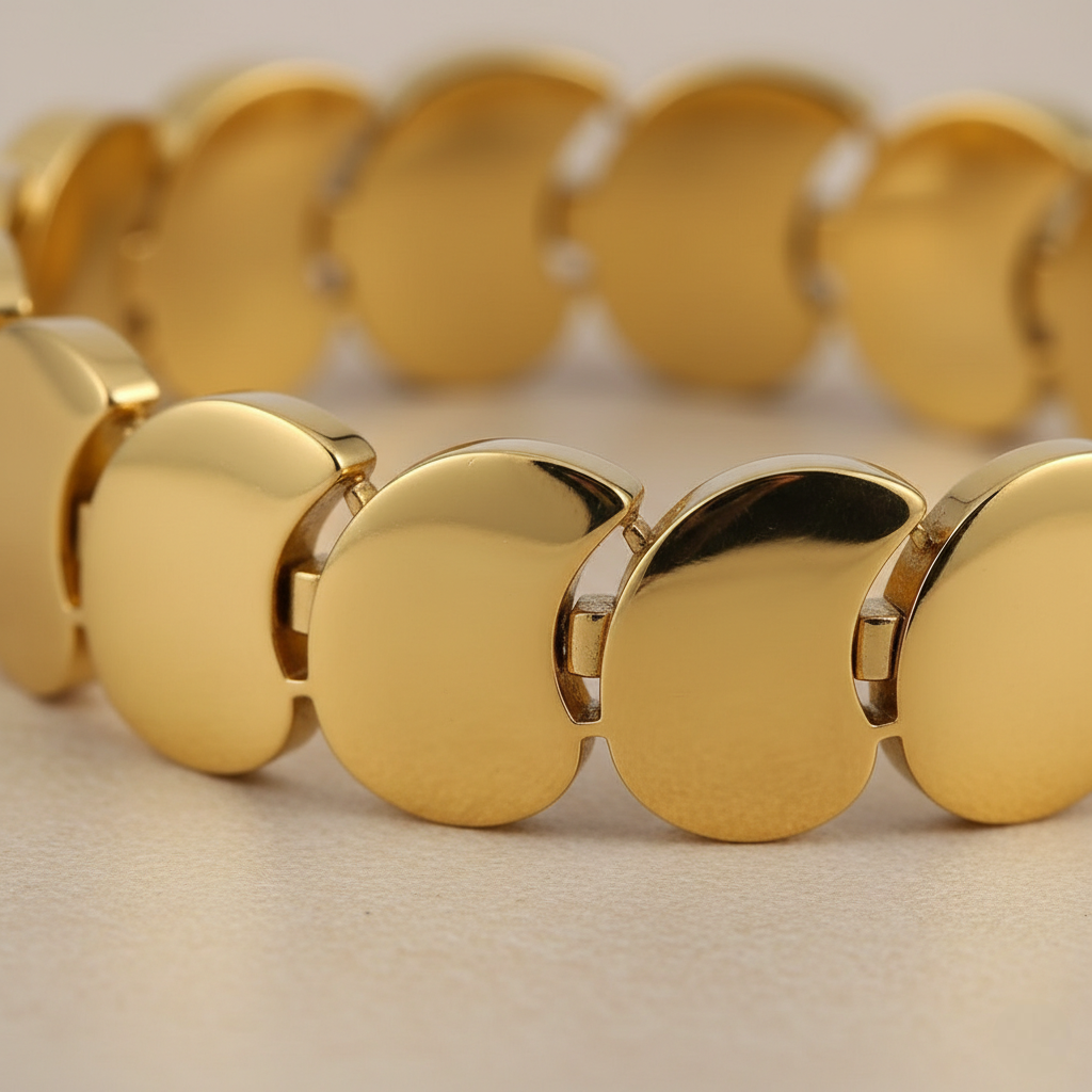 Gold bracelet with circular links on a beige background