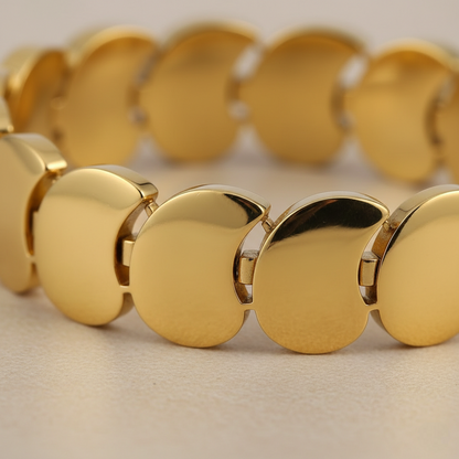 Gold bracelet with circular links on a beige background