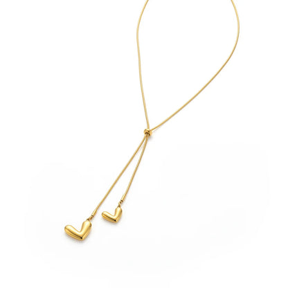 Gold necklace with heart pendants on a white background