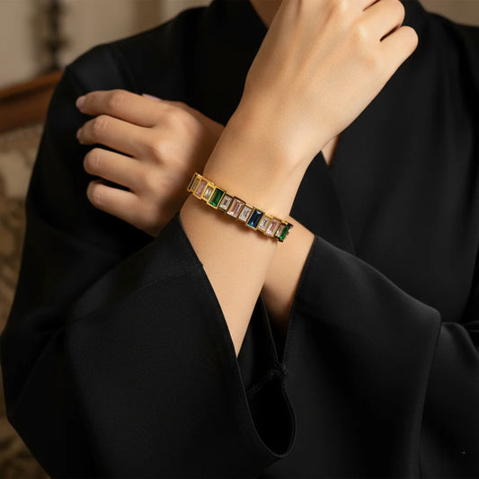 Bracelet with gemstones on a person's wrist against a dark background