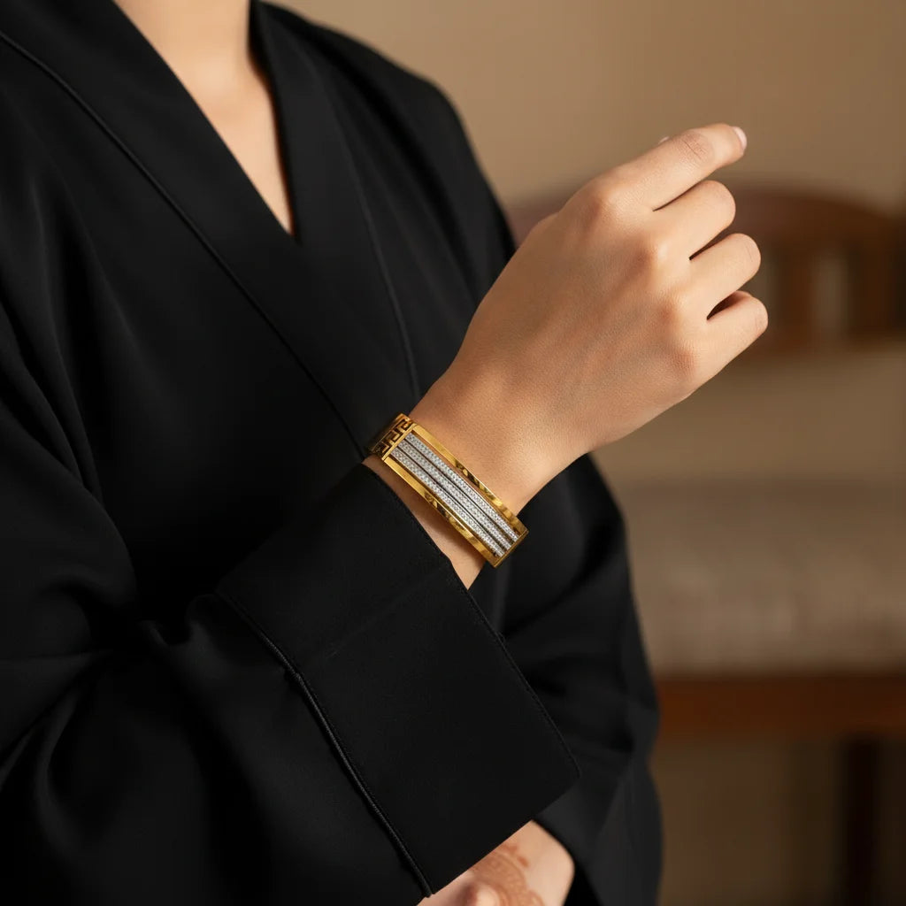 Person wearing a gold bracelet with a blurred background