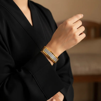 Person wearing a gold bracelet with a blurred background