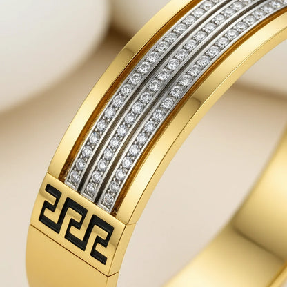 Gold ring with diamond accents and a Greek key design on a beige background