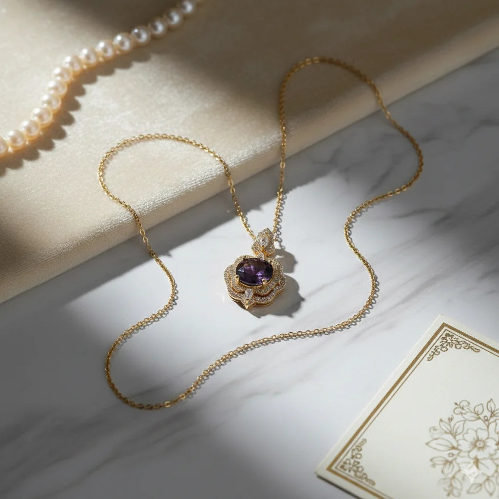 Gold necklace with a purple gemstone pendant on a marble surface