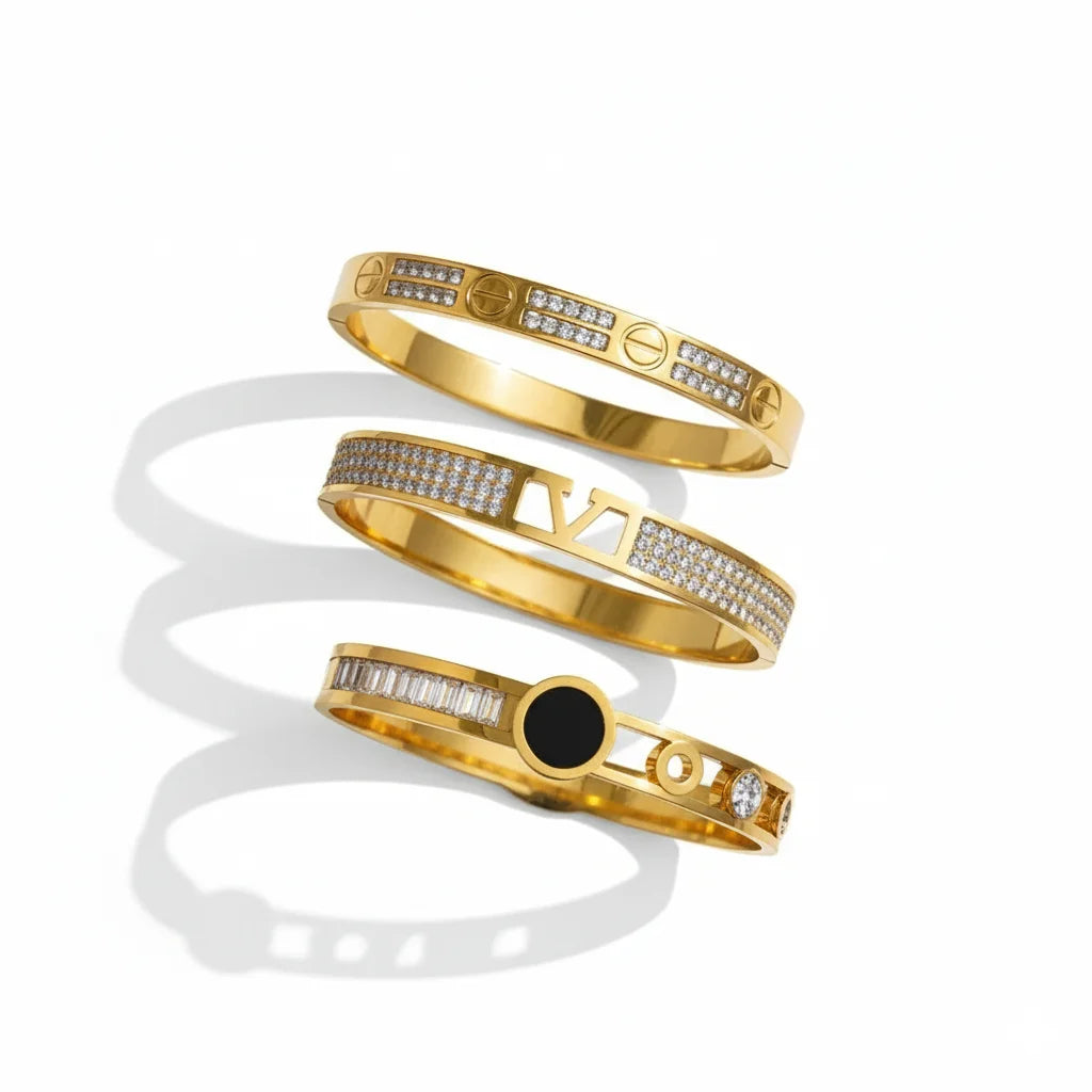 Three gold bracelets with different designs on a white background