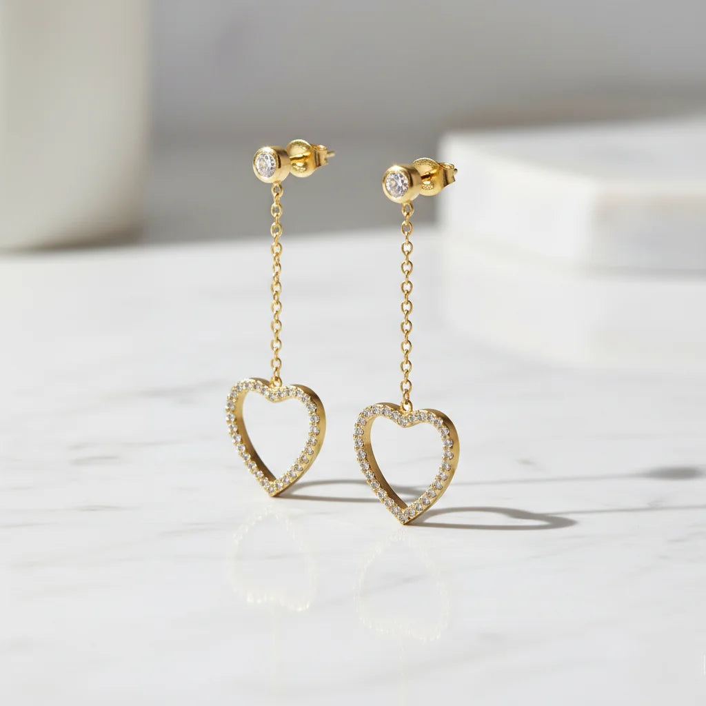 Gold heart-shaped earrings on a light background