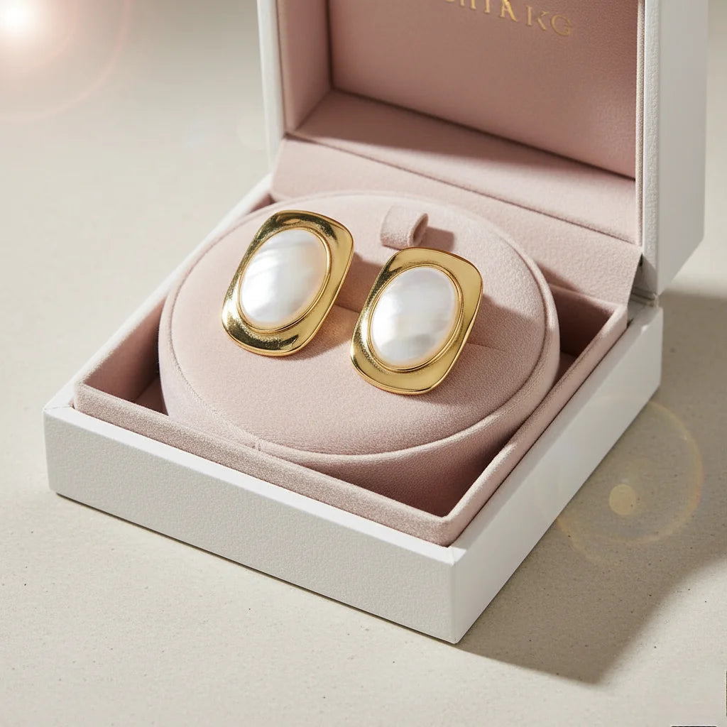 Gold and pearl earrings in a pink jewelry box