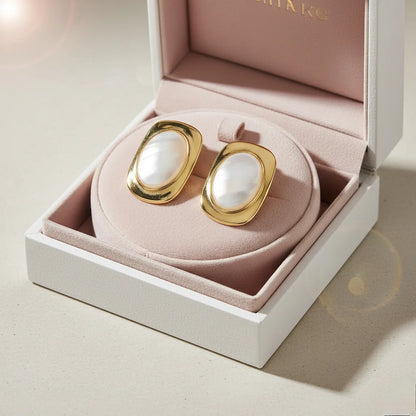 Gold and pearl earrings in a pink jewelry box