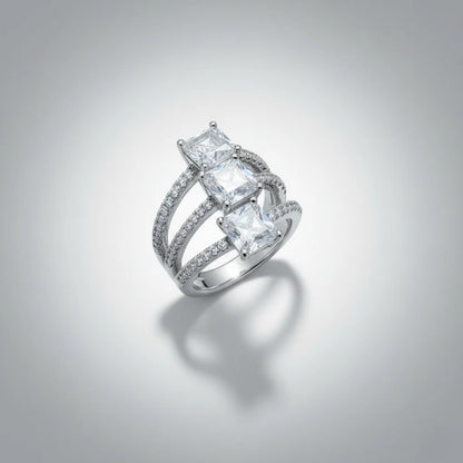 Silver ring with princess-cut diamonds on a gray background
