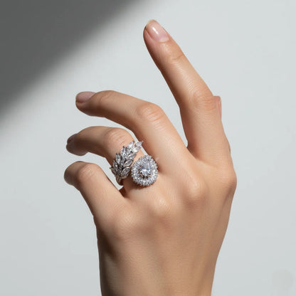Hand wearing two diamond rings on a neutral background