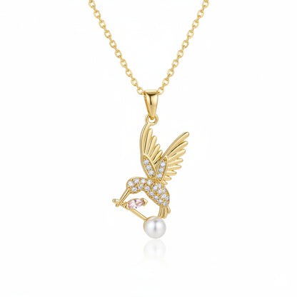 Gold necklace with a pendant featuring wings and a pearl on a white background