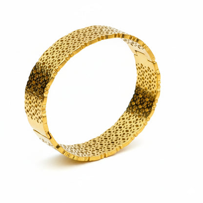 Gold bracelet with textured surface on a white background