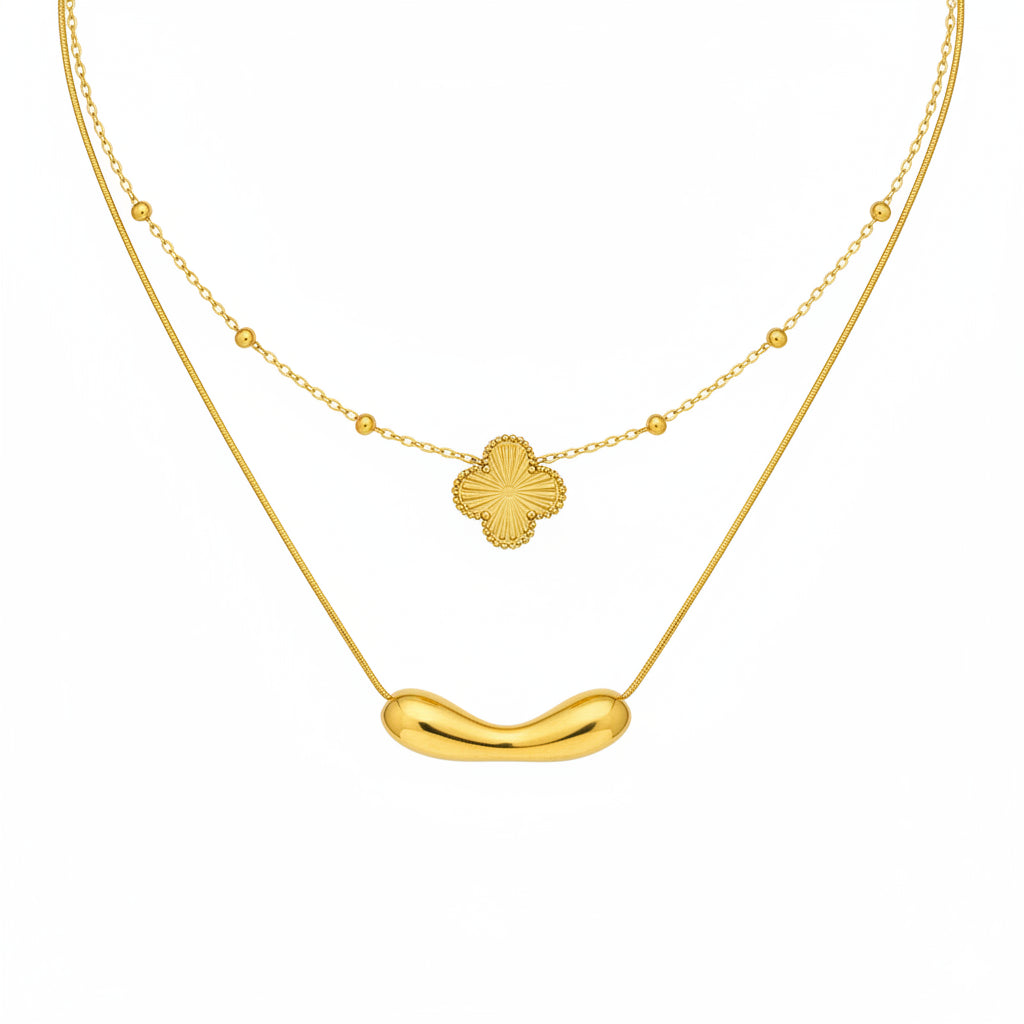 Two gold necklaces with floral and curved pendants on a white background