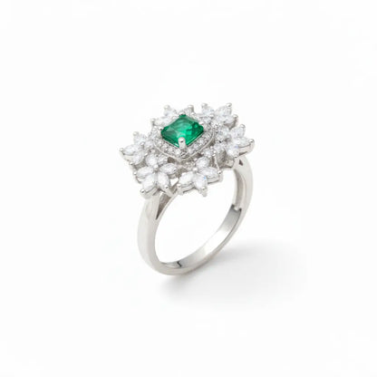 Silver ring with a green gemstone and diamond-like stones on a white background