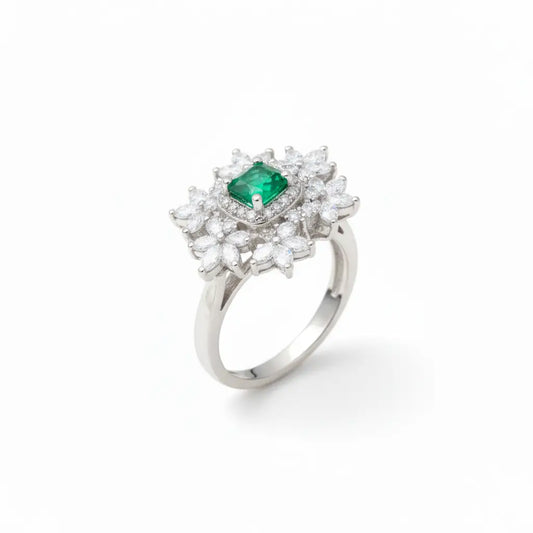 Silver ring with a green gemstone and diamond-like stones on a white background