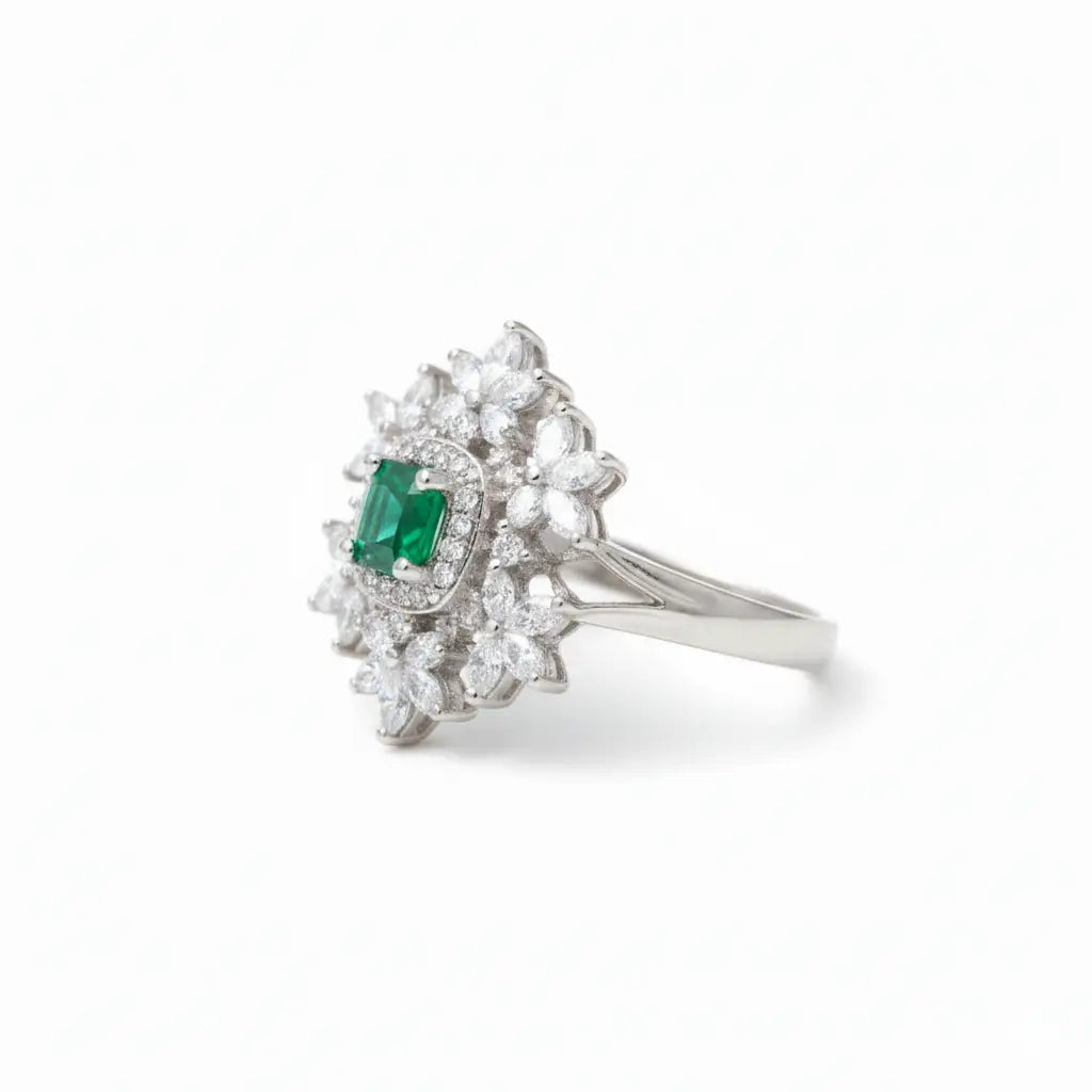 Silver ring with emerald and diamonds on a white background