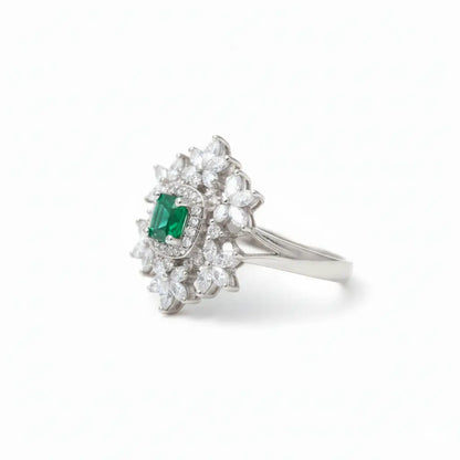 Silver ring with emerald and diamonds on a white background