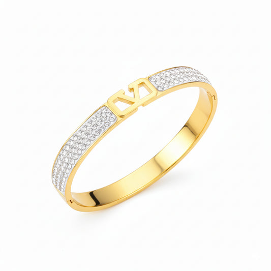 Gold bracelet with diamond accents on a white background