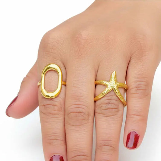 Hand wearing two gold rings on a white background