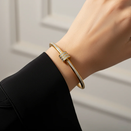 Gold bracelet on a wrist with a neutral background