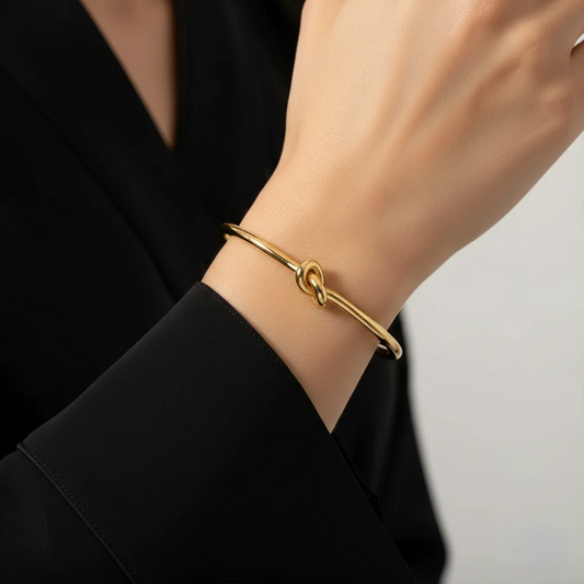 Gold bracelet on a person's wrist with a blurred background