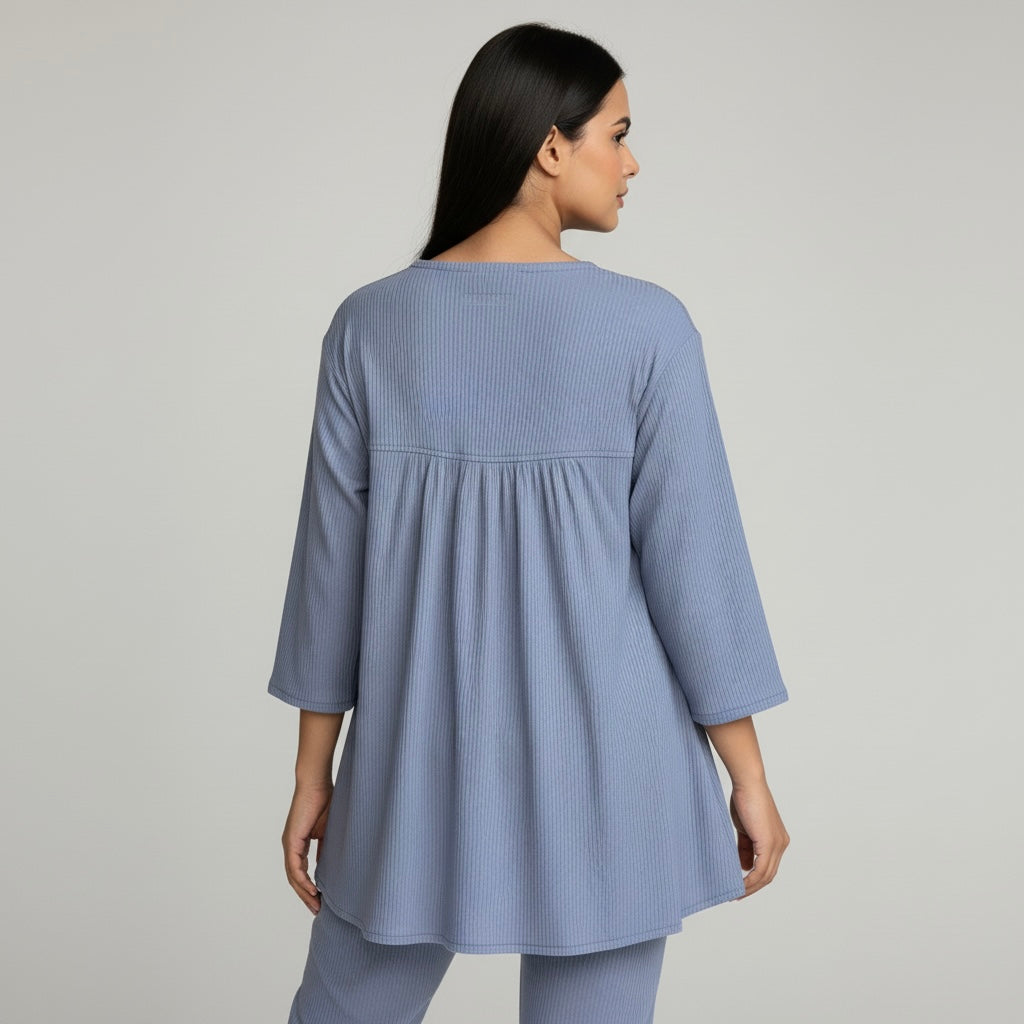 Woman wearing a blue textured dress against a gray background