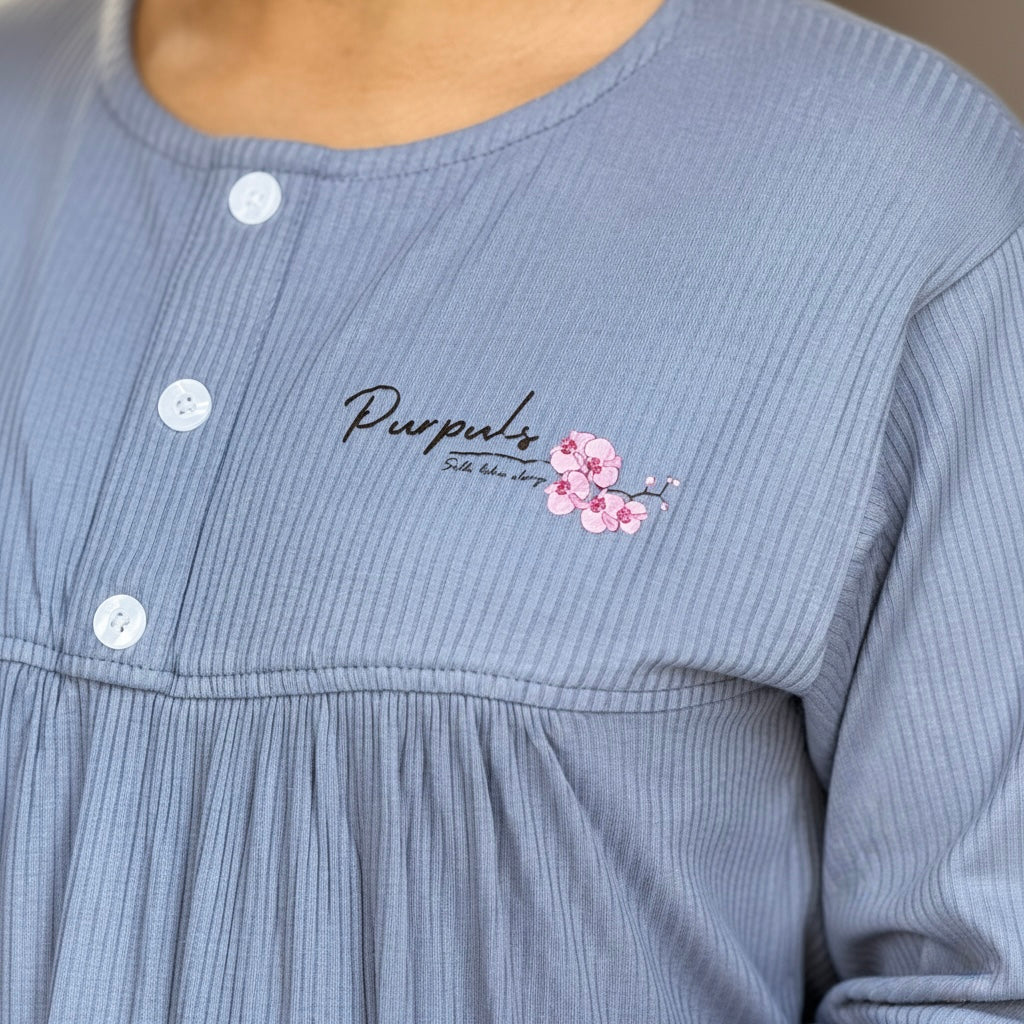 Blue ribbed garment with 'Purpuls' branding and floral design on a neutral background