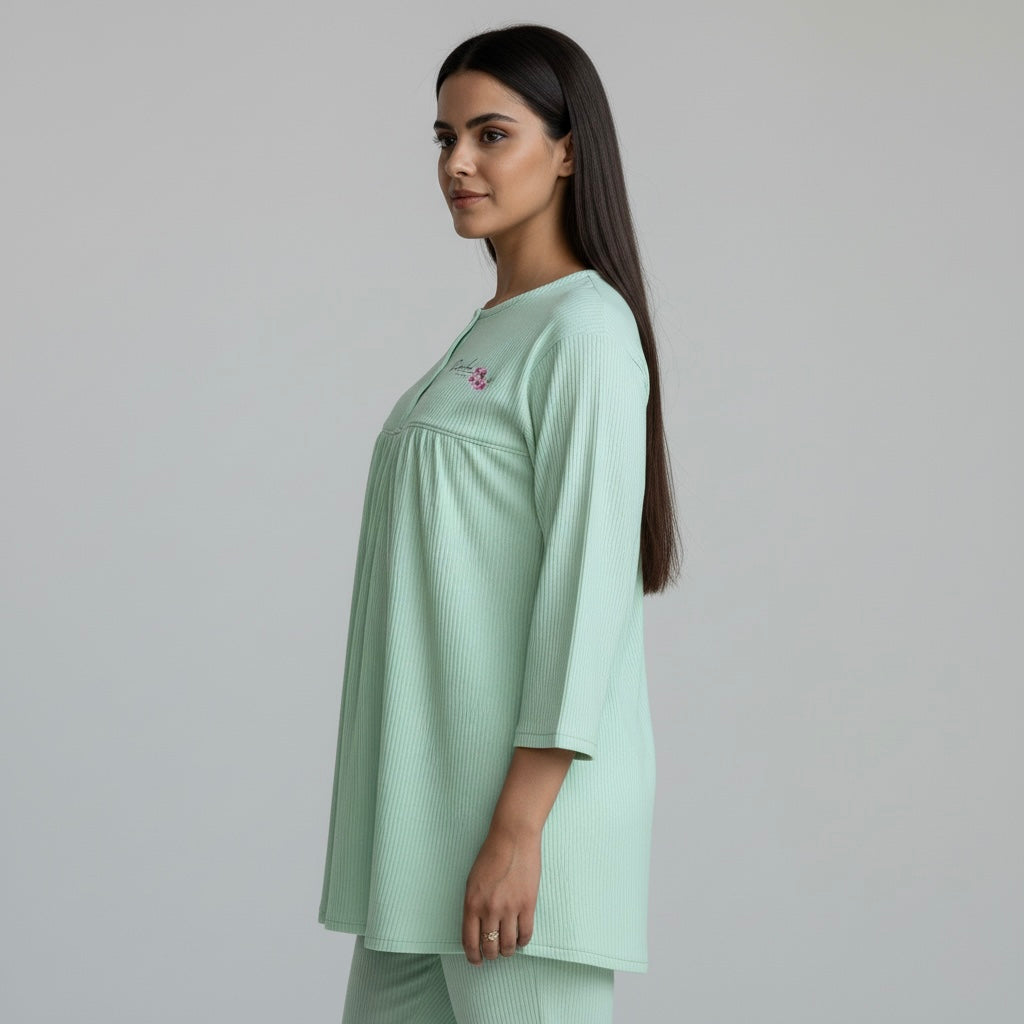 Woman wearing a light green outfit against a plain background