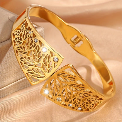 Gold bangles with intricate leaf patterns and embedded stones on a beige fabric background