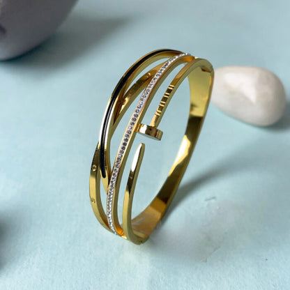 Gold bracelet with diamond accents on a light blue background