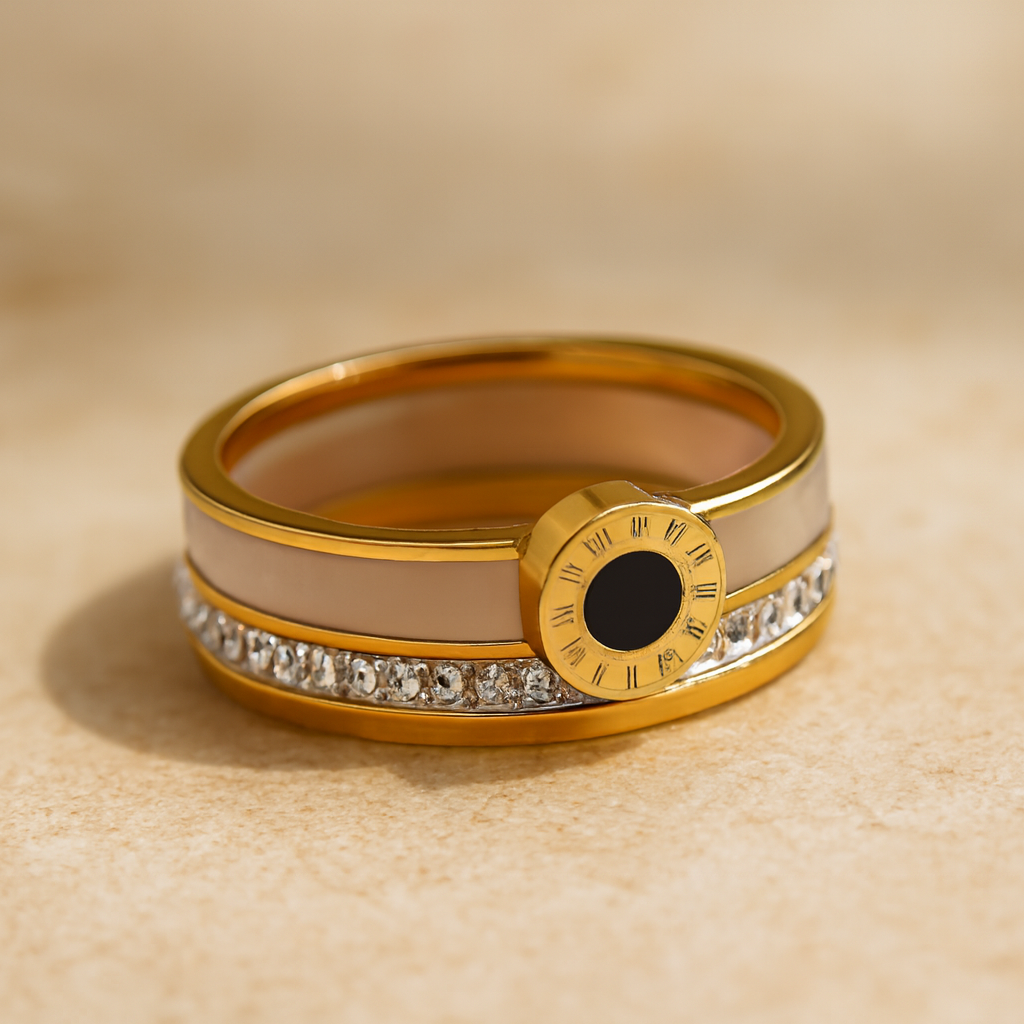 Gold ring with black center and diamond accents on a beige background