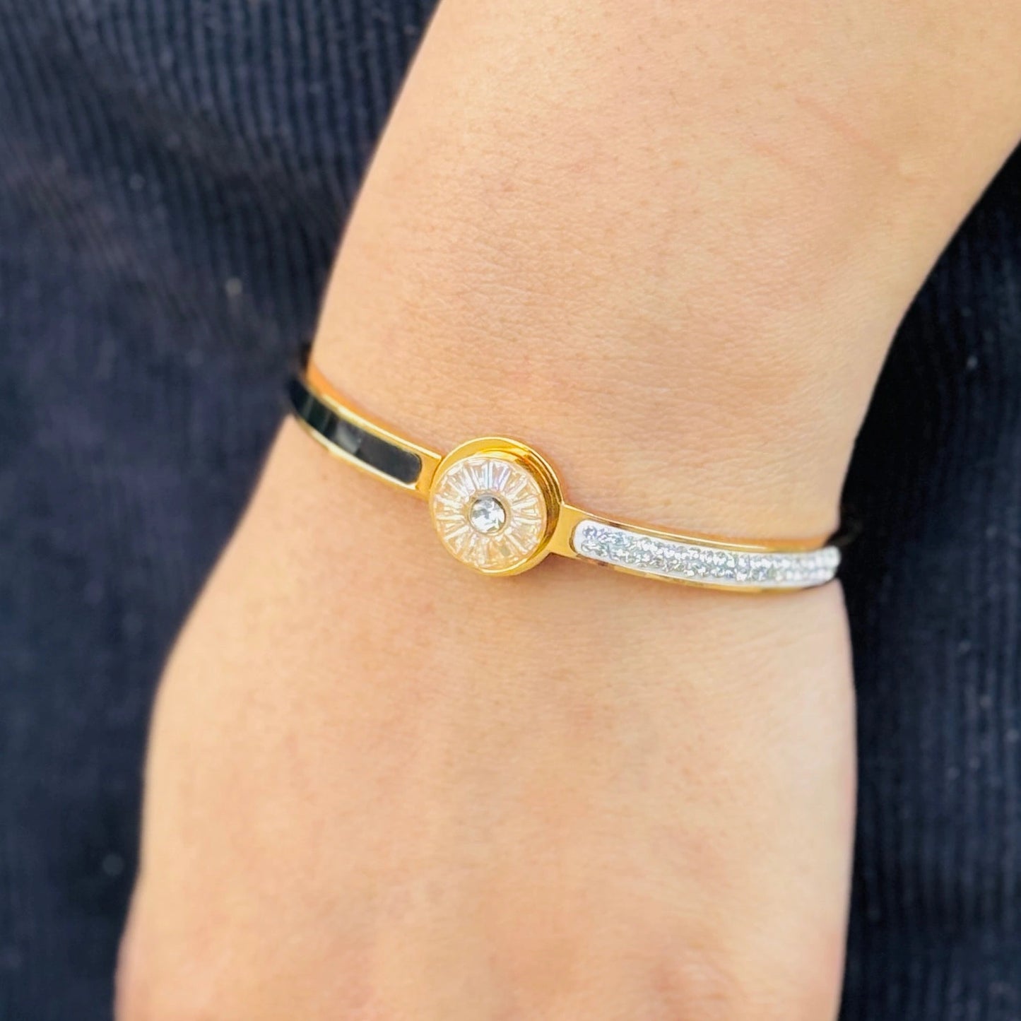 Gold and silver bracelet on a wrist with a blurred background