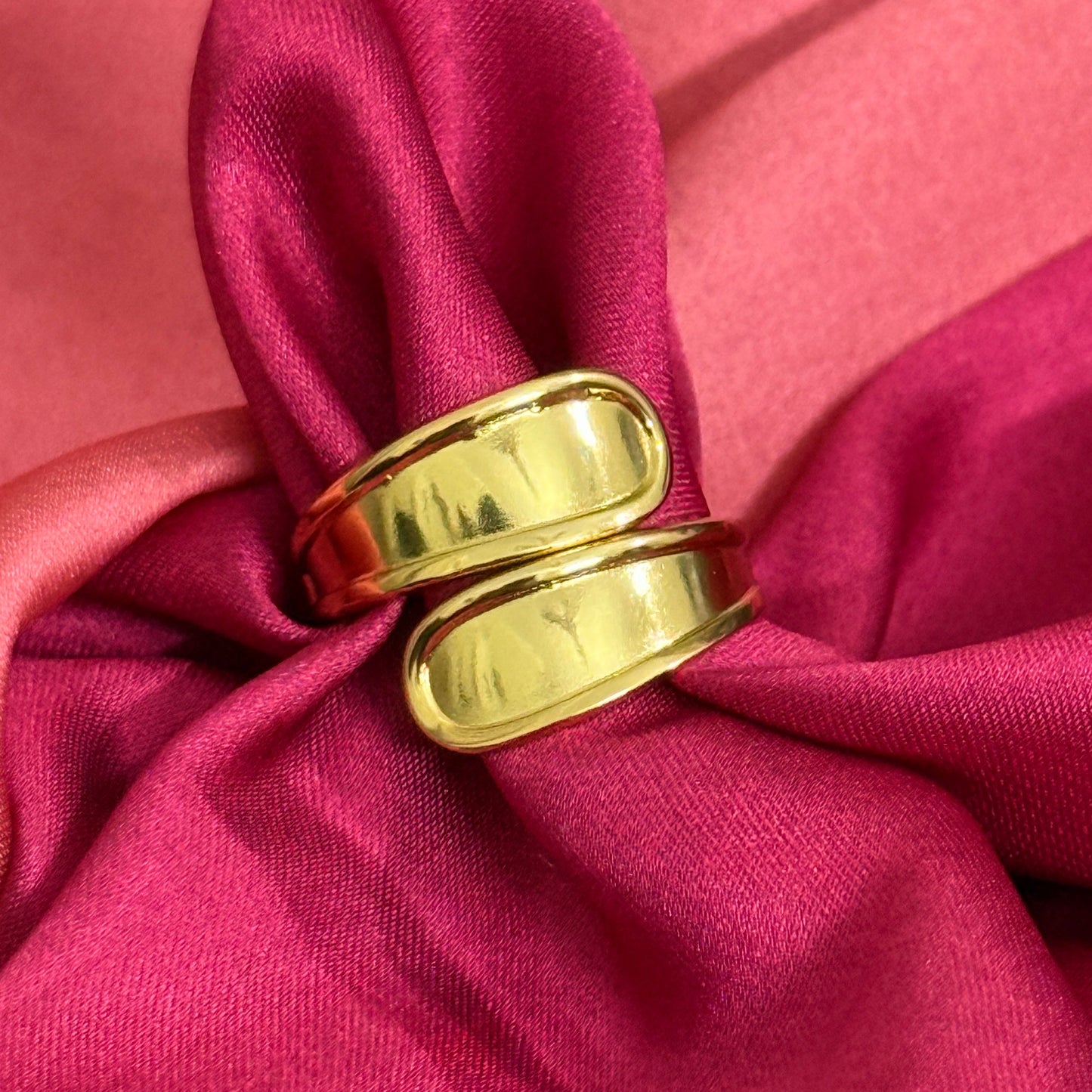 Gold rings on a pink fabric background