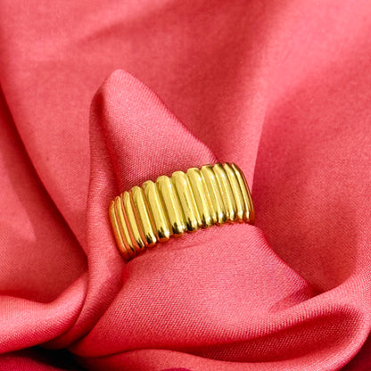 Gold ring on a pink fabric background