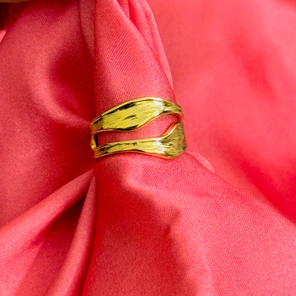 Gold ring on a pink fabric background