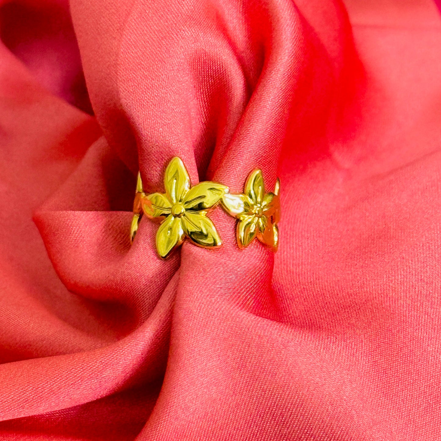 Gold floral ring on a red fabric background