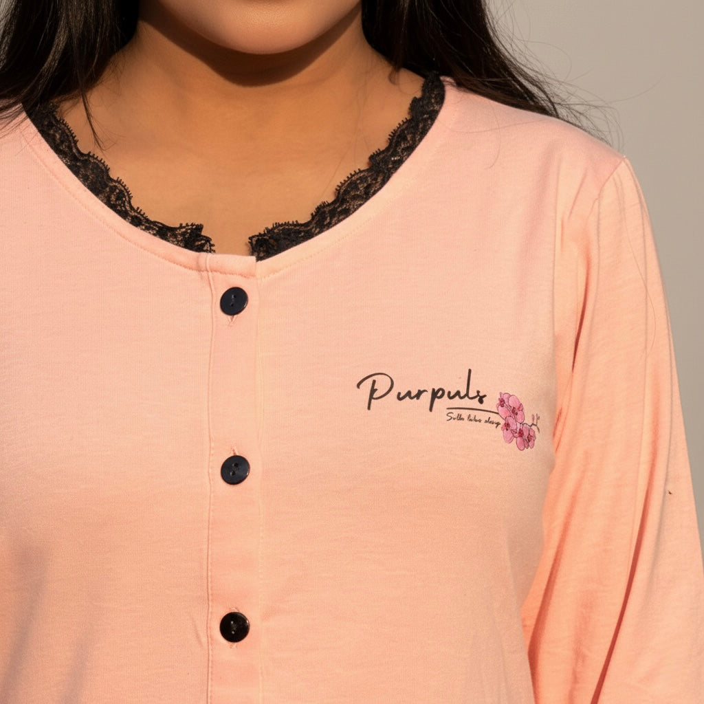 Close-up of a peach-colored shirt with black lace trim and 'Purples' branding.