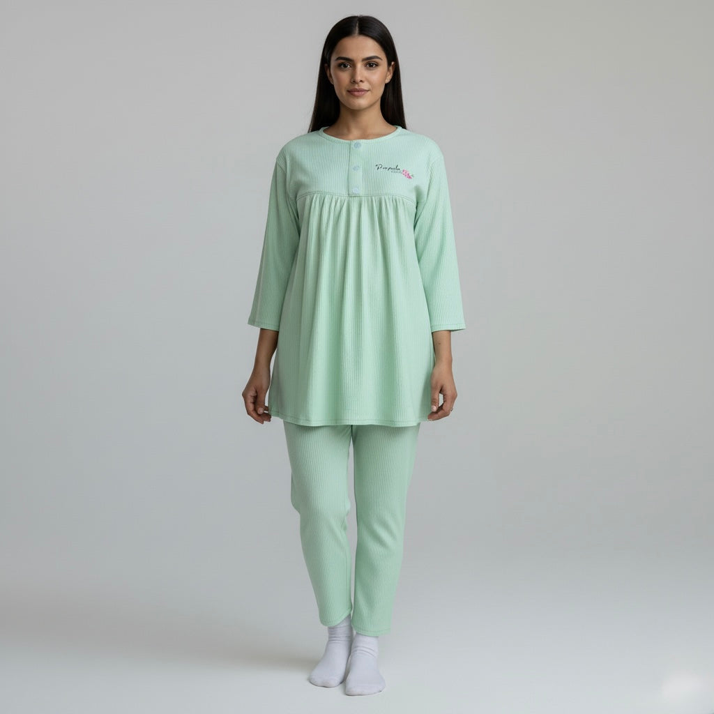 Woman wearing a light green pajama set on a plain background
