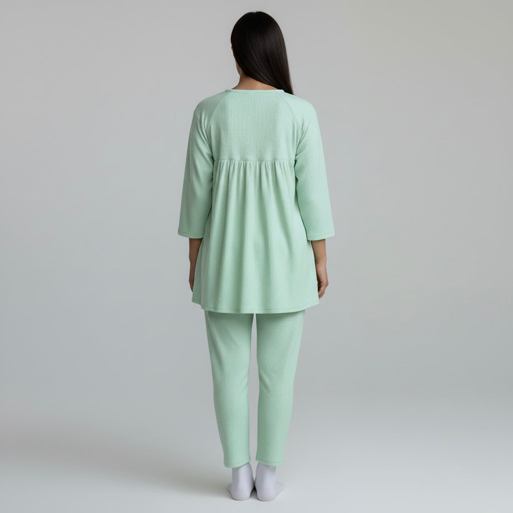 Person wearing a light green outfit on a plain background