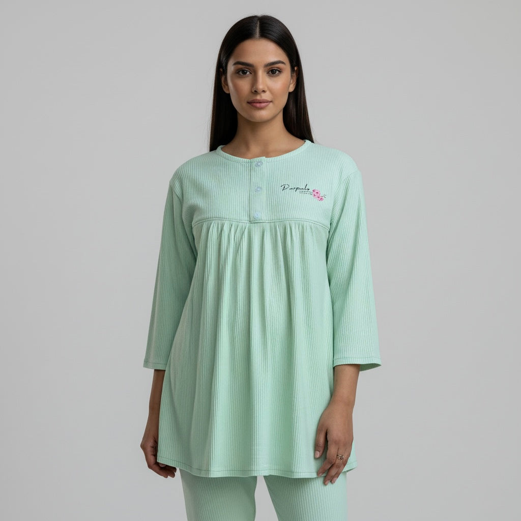 Woman wearing a light green dress with a subtle pattern on a plain background