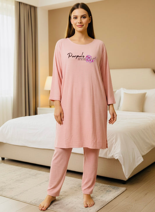 Woman wearing a pink nightgown with a brand logo in a bedroom setting